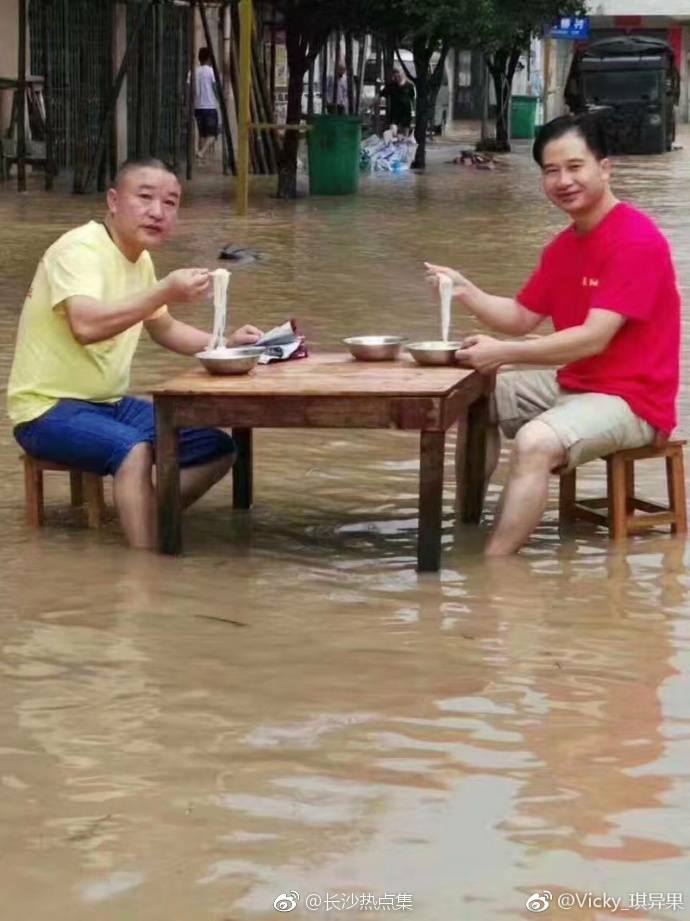 ไม่หวั่นแม้น้ำมามาก! โซเชียลจีนแห่แชร์รูปชายชาวจีนนั่งกินข้าวกลางน้ำท่วม ที่ฉางซ…
